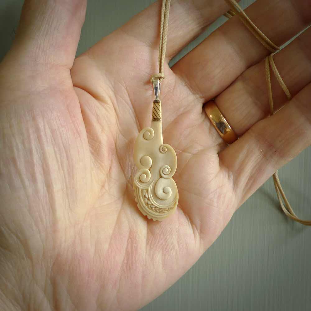 Hand carved engraved woolly mammoth tusk patu necklace hand made here in New Zealand. One only artistic patu pendant. Shipped to you with Express Courier. Stand out patu pendant for men and women. Mammoth tusk patu, art to wear.