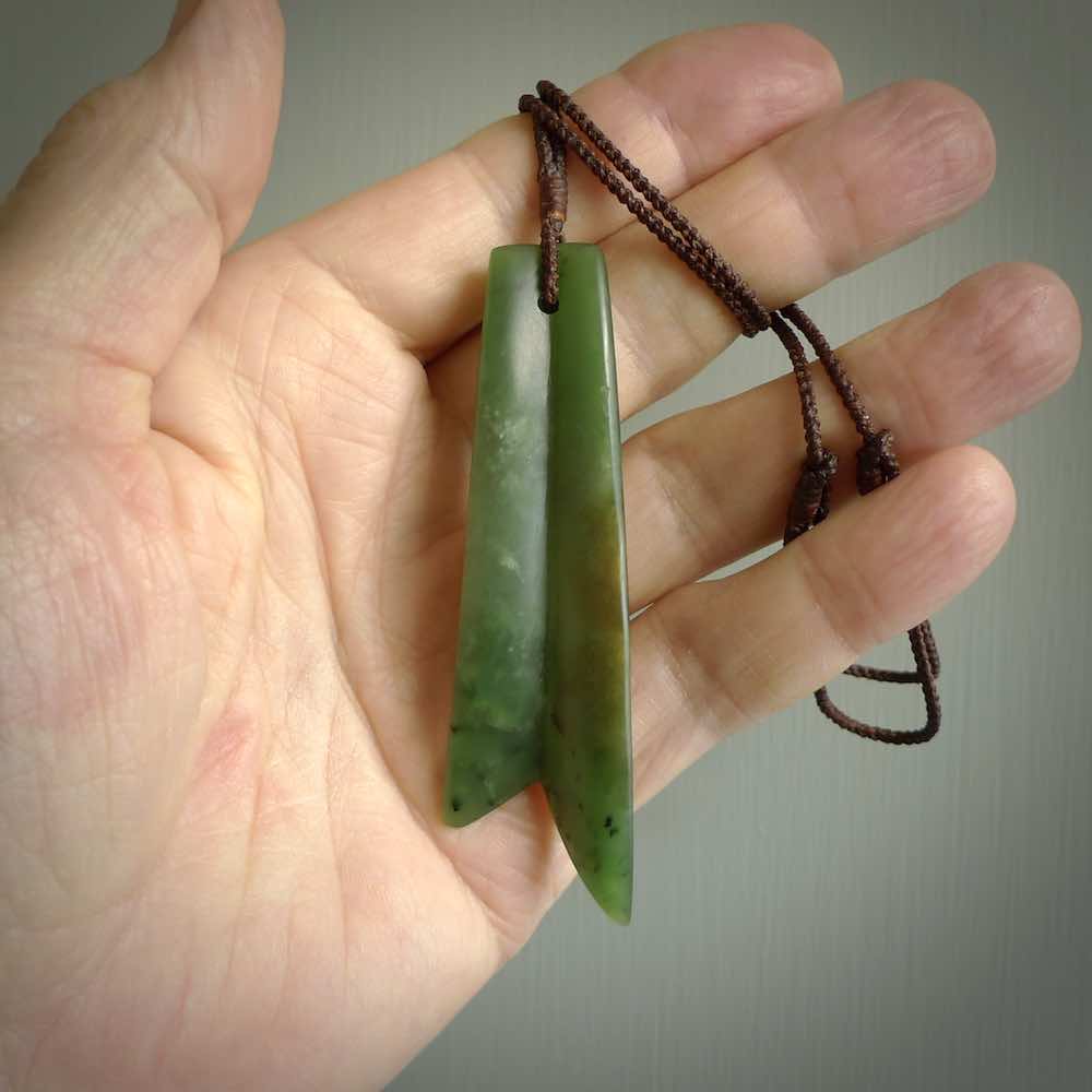 This piece is a fine, delicate pendant. It was carved for us by Ric Moor from a lovely semi-translucent green piece of New Zealand Marsden jade. It is suspended on an dark brown  four plaited braided cord that is length adjustable.