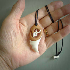 A hand carved bone contemporary bird pendant. The cord is a black colour and is a fixed length. A medium sized hand made contemporary necklace by New Zealand artist Kerry Thompson. Kerry has stained parts of the bone which really add to the dimension of this pendant. One off work of art to wear.