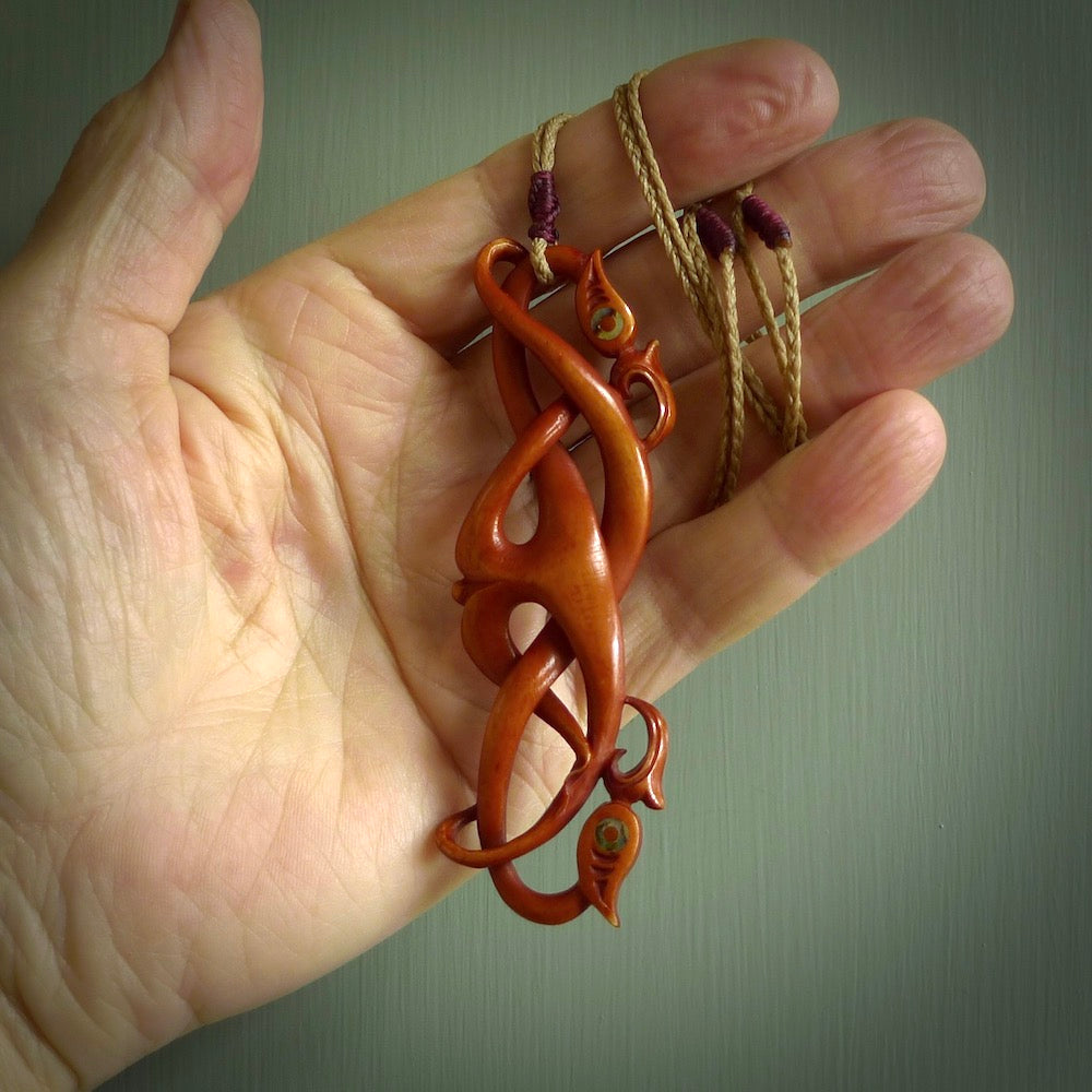 This necklace is carved from cow bone and stained with a homemade tea dye. It is a unique piece of wearable art that is sure to catch the eye. The shape is a complex twist form and has been beautifully hand carved by bone carver Yuri Terenyi.