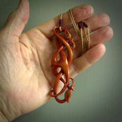 This necklace is carved from cow bone and stained with a homemade tea dye. It is a unique piece of wearable art that is sure to catch the eye. The shape is a complex twist form and has been beautifully hand carved by bone carver Yuri Terenyi.