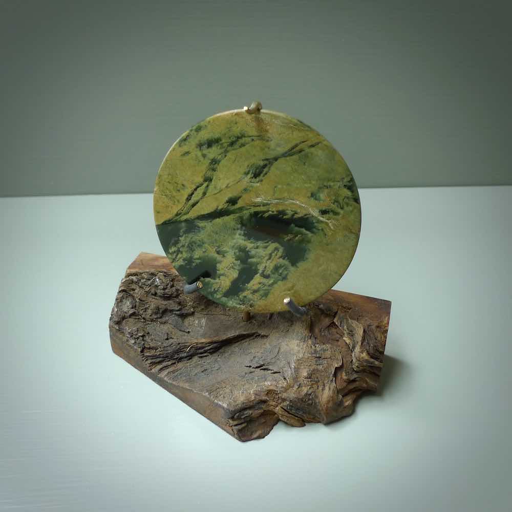 Hand carved New Zealand Flower Jade Disc with wooden stand sculpture. Hand carved here in New Zealand by Alex Sands Studio. This is a 'one only' sculpture, a beautiful display piece.