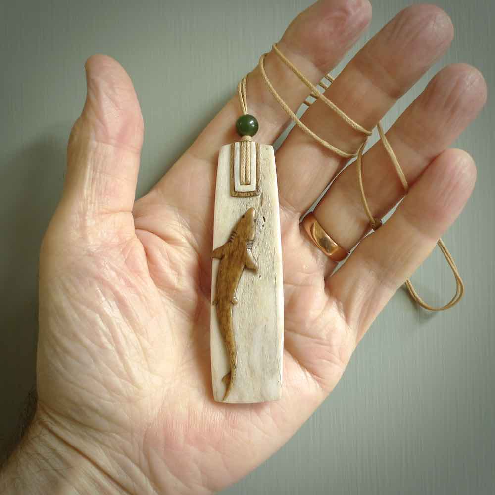 Hand carved Whale Bone Toki by Alex Sands Studio. One only New Zealand whale bone toki with shark engraving necklace for men and women. Unique New Zealand art to wear. Shipped to you on an adjustable cord. 