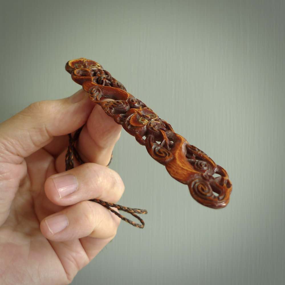 This necklace is carved from cow bone and stained with a homemade tea dye. It is a unique piece of wearable art that is sure to catch the eye. The shape is a complex twist form and has been beautifully hand carved by bone carver Yuri Terenyi.