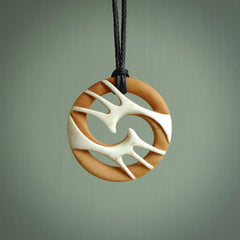 A hand carved bone contemporary, intricate pendant. The cord is a black colour and is a fixed length. A medium sized hand made contemporary necklace by New Zealand artist Kerry Thompson. Kerry has stained parts of the bone which really add to the dimension of this pendant. One off work of art to wear.