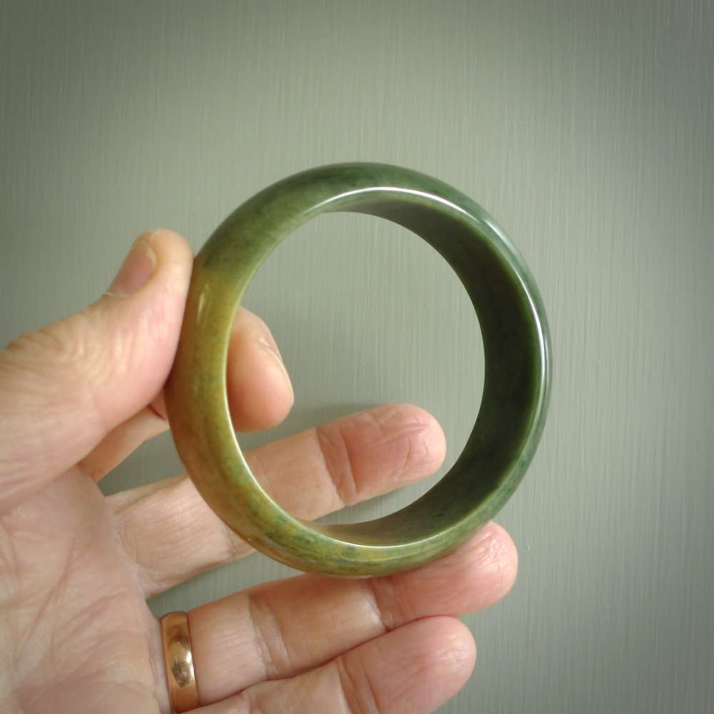 Hand carved jade bangle. Carved from green New Zealand jade. This is a solid jade bangle carved from a single piece of jade. It is polished to a soft shine. the jade is otherwise untreated and completely natural.