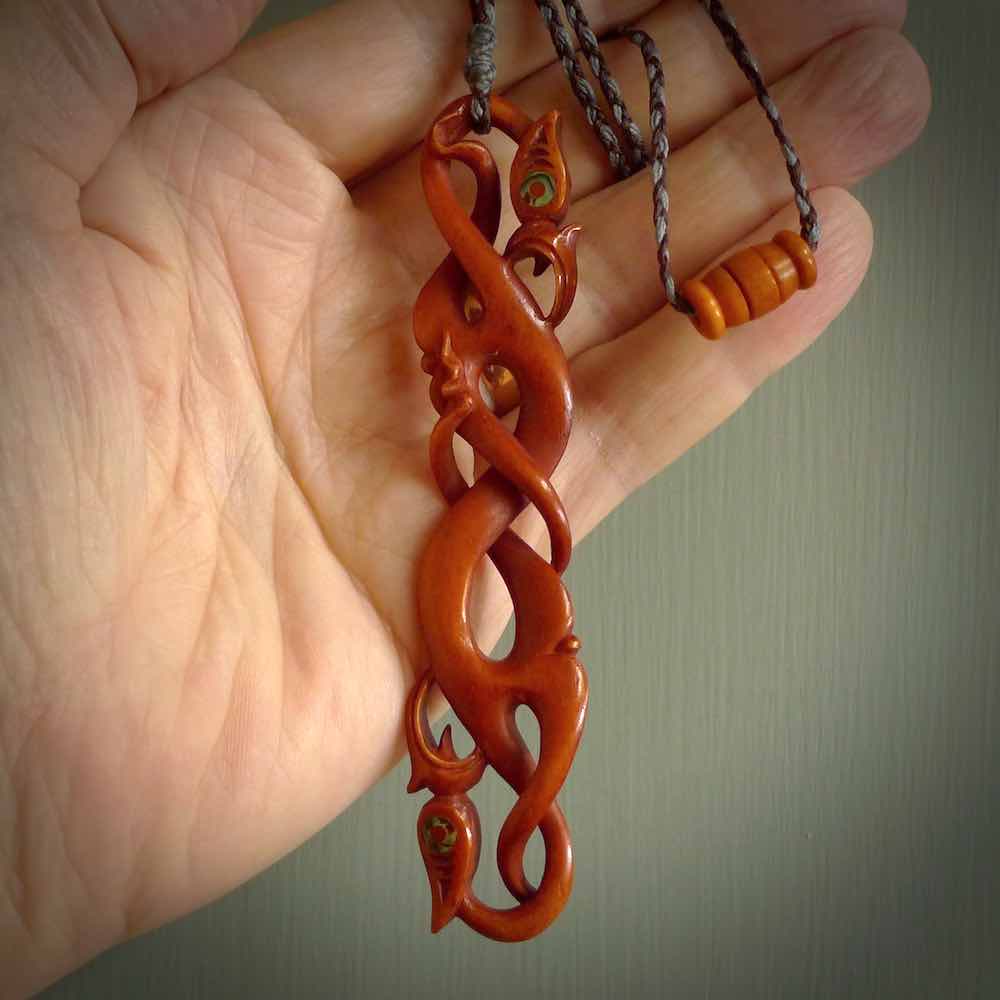 This necklace is carved from cow bone and stained with a homemade tea dye. It is a unique piece of wearable art that is sure to catch the eye. The shape is a complex twist form and has been beautifully hand carved by bone carver Yuri Terenyi.