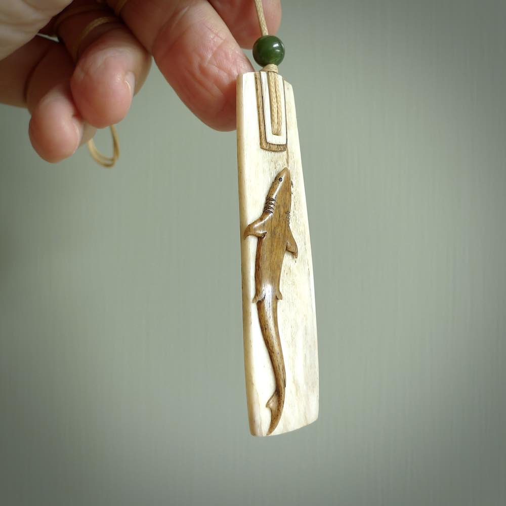 Hand carved Whale Bone Toki by Alex Sands Studio. One only New Zealand whale bone toki with shark engraving necklace for men and women. Unique New Zealand art to wear. Shipped to you on an adjustable cord. 