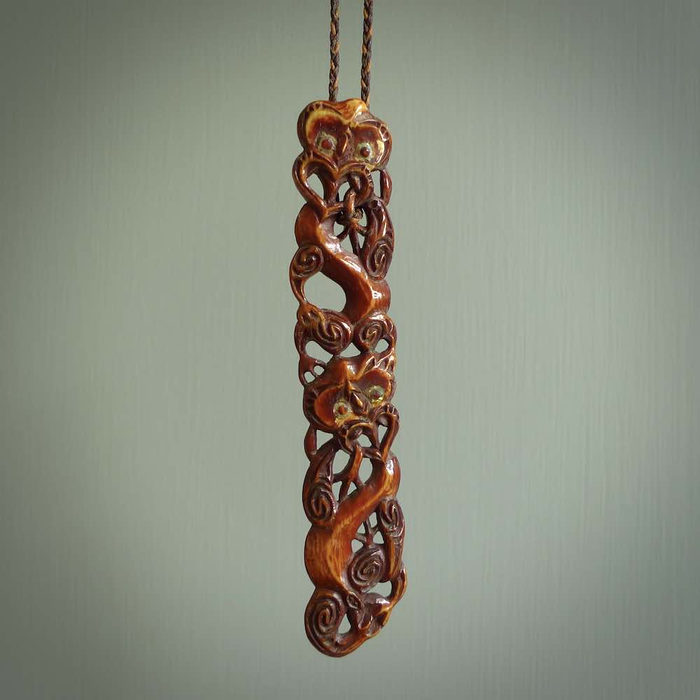 This necklace is carved from cow bone and stained with a homemade tea dye. It is a unique piece of wearable art that is sure to catch the eye. The shape is a complex twist form and has been beautifully hand carved by bone carver Yuri Terenyi.