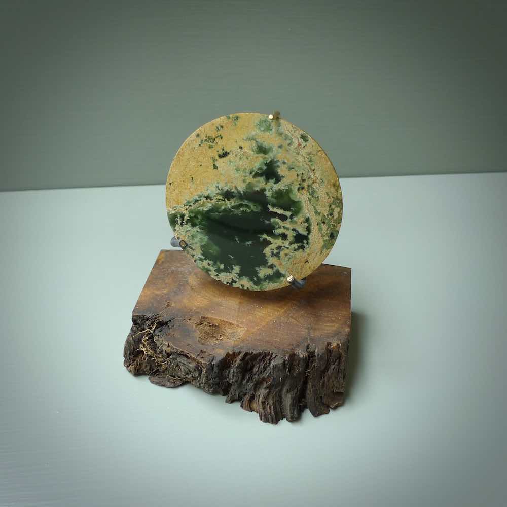 Hand carved New Zealand Flower Jade Disc with wooden stand sculpture. Hand carved here in New Zealand by Alex Sands Studio. This is a 'one only' sculpture, a beautiful display piece.