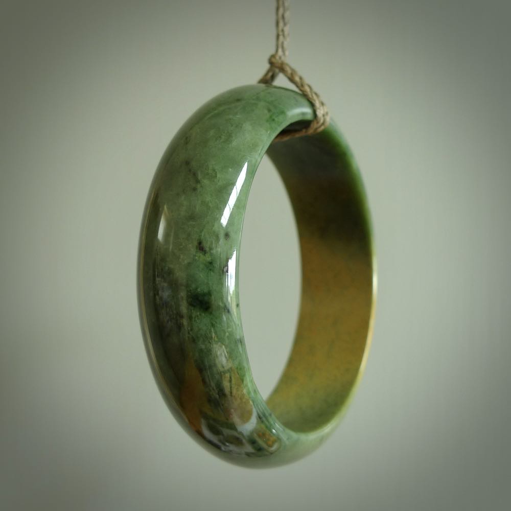 Hand carved jade bangle. Carved from green New Zealand jade. This is a solid jade bangle carved from a single piece of jade. It is polished to a soft shine. the jade is otherwise untreated and completely natural.