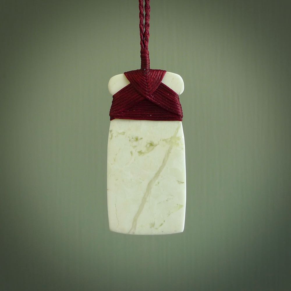 This pendant is a lovely toki carved from white onyx stone. It is a traditional shape and is traditionally bound but carved from a striking white stone. A beautiful piece of handmade jewellery from NZ Pacific.