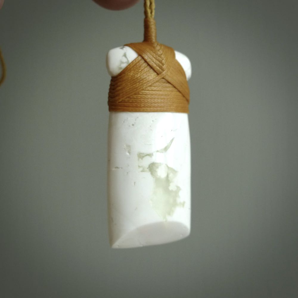 This pendant is a lovely toki carved from white onyx stone. It is a traditional shape and is traditionally bound but carved from a striking white stone. A beautiful piece of handmade jewellery from NZ Pacific.