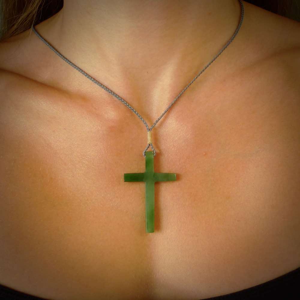 Hand carved jade cross. Made from New Zealand jade. Christian cross for sale online.This picture shows a green jade cross suspended on a fine, plaited cord. The cross is hand carved jade cross. Made from New Zealand jade. Christian cross for sale online.