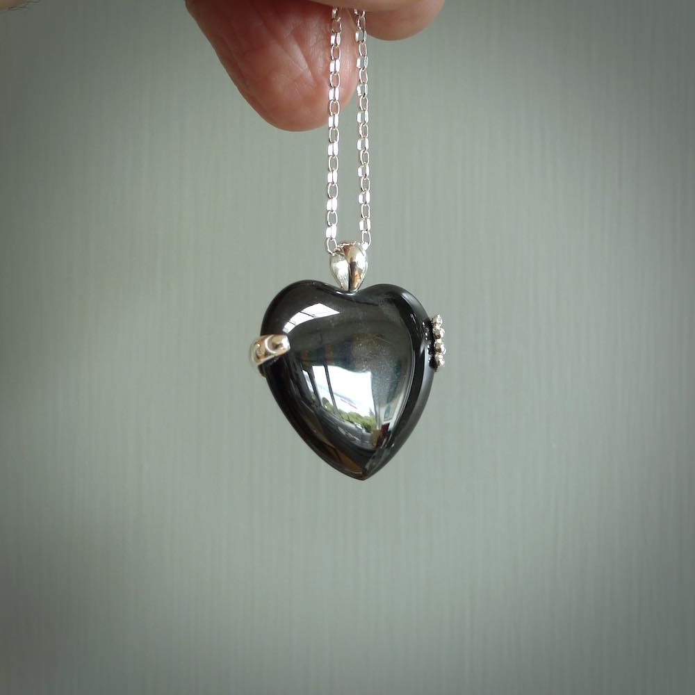 Hand crafted Australian Black jade heart in sterling silver hand necklace. This piece has a sterling silver hand holding a Black Jade heart. This necklace is provided with a sterling silver chain.